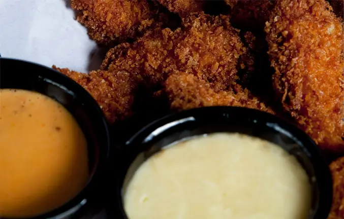 An image of crispy chicken with dipping sauces.